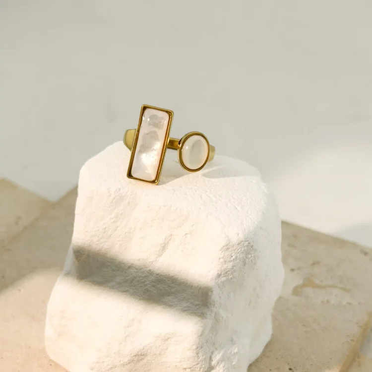 Ανακάλυψε το Ophelia Ring, ένα ρυθμιζόμενο δαχτυλίδι από ανοξείδωτο ατσάλι με χρυσό φινίρισμα και ιριδίζουσες λευκές πέτρες που χαρίζουν μοναδική λάμψη
