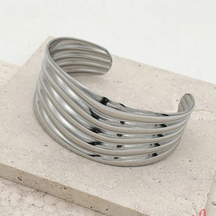 Αποκτήστε το Wavy Lines Cuff, ένα ανοιχτό βραχιόλι με κομψές κυματιστές λωρίδες που ταιριάζει σε κάθε καρπό. Επιλέξτε ανάμεσα σε χρυσό ή ασημί χρώμα